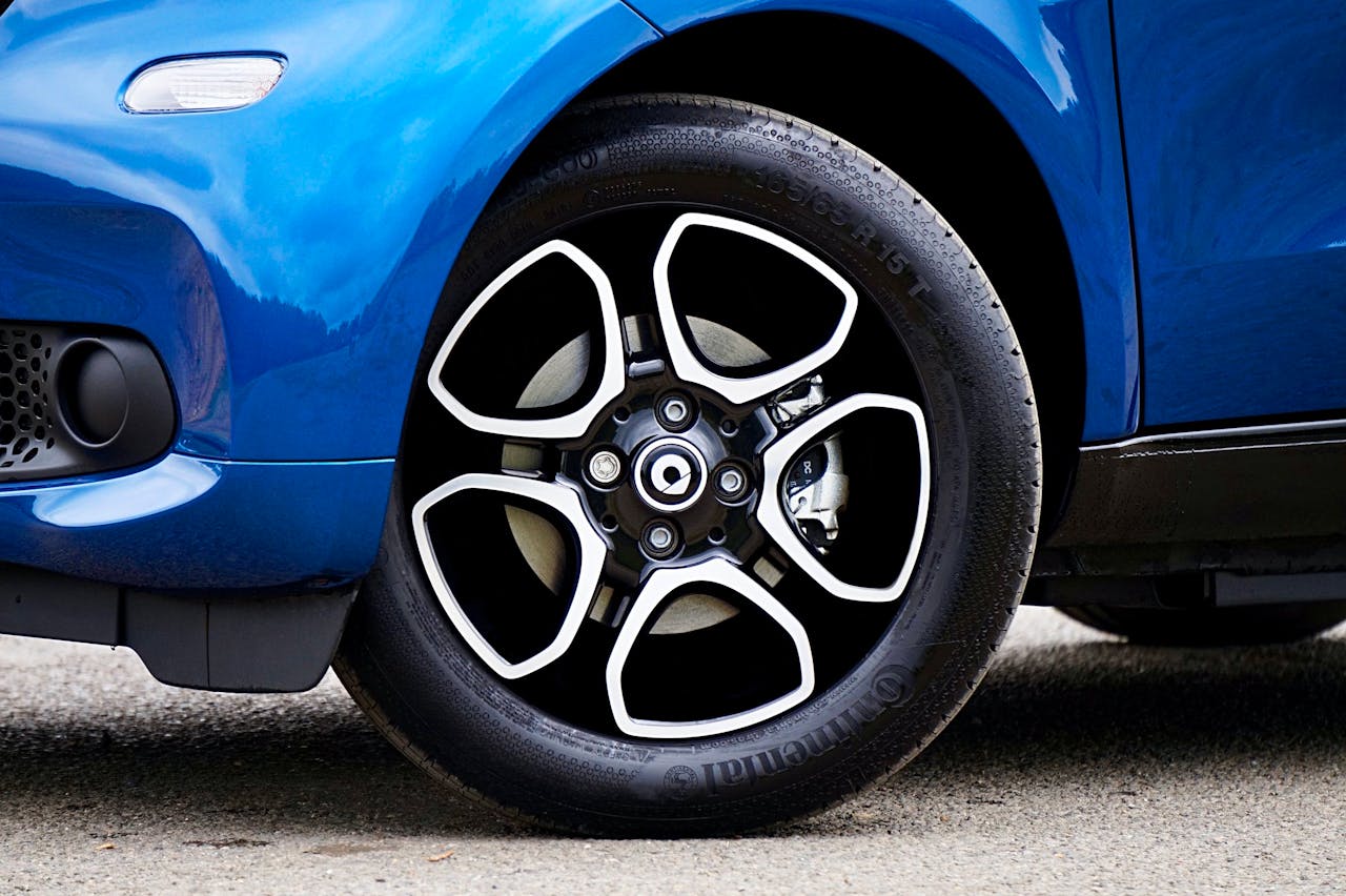 Detailed close-up shot of a blue car's tire and wheel in the UK.
